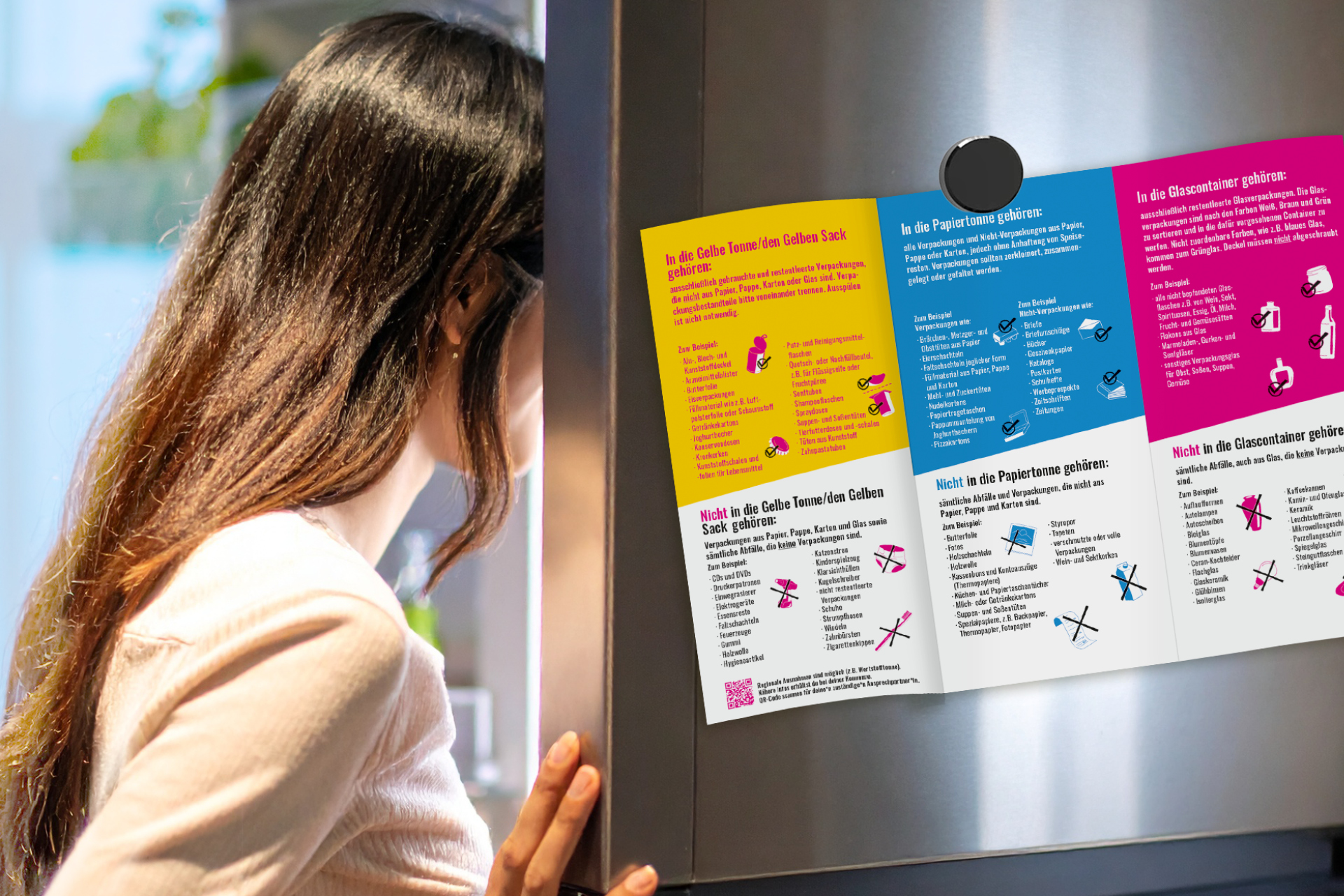 Frau mit langen dunklen Haaren liest Informationsflyer mit farbigen Abschnitten an einer Wand